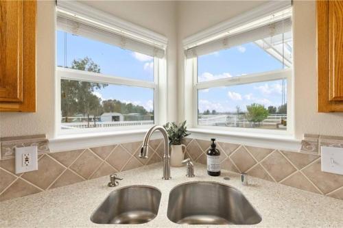 a kitchen with two sinks and two windows at Our Farmhouse, Our Place: Cozy and Cute homestead! in Paso Robles