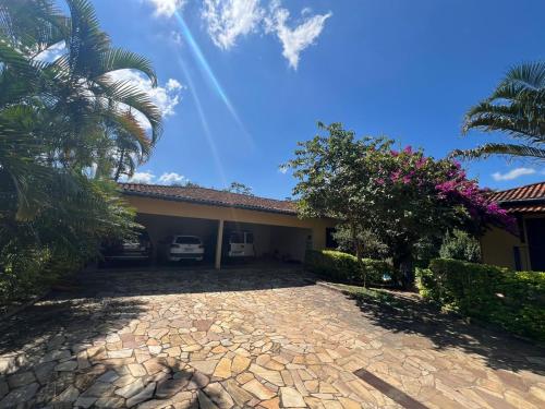a house with a palm tree and a driveway at Pousada dos Girassóis in Conservatória