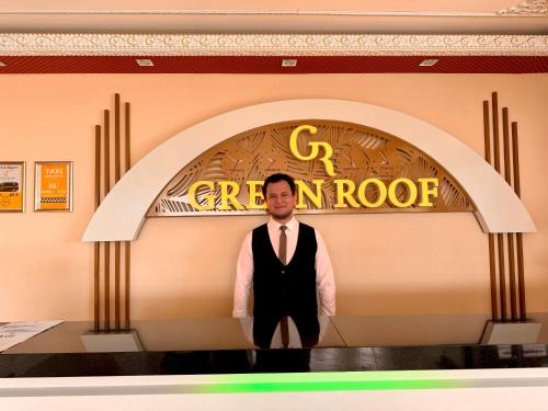 a man in a tie standing in front of a restaurant at Green Roof Boutique Hotel & Spa in Terkos