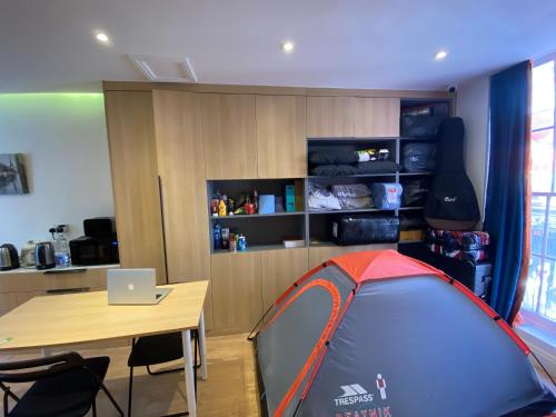 een kamer met een tent, een bureau en een tafel bij Little wooden Hut in Londen
