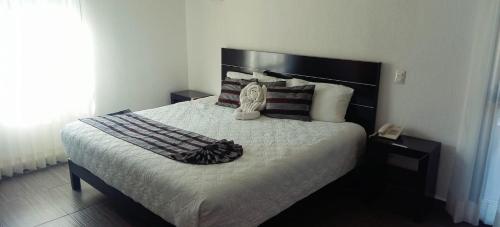 um quarto com uma cama grande e um telefone. em HOTEL PUNTA GALERIA em Morelia