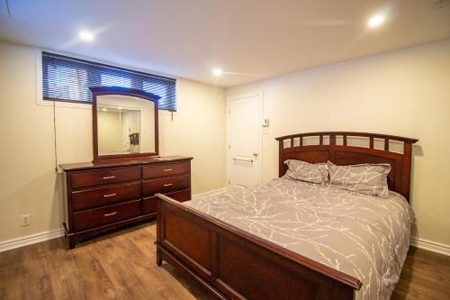 - une chambre avec un lit, une commode et un miroir dans l'établissement L'Oasis Urbaine, à Saint-Hubert