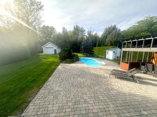 a backyard with a swimming pool and a building at L'Oasis Urbaine in Saint-Hubert