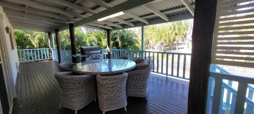 a porch with a table and chairs on a deck at Cabbage Palm Holiday Home in Agnes Water
