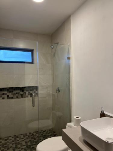 a bathroom with a shower and a toilet and a sink at Nohemani Suite in Monterrey