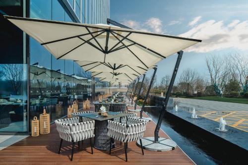 a restaurant with tables and chairs and an umbrella at Crowne Plaza Ezhou, an IHG Hotel in Ezhou