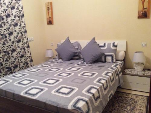 馬拉喀什的住宿－Apartment Majdoline，一间卧室配有一张带蓝色和灰色枕头的床