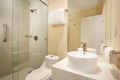 a bathroom with a sink and a toilet and a shower at One Saltillo Aeropuerto in Saltillo