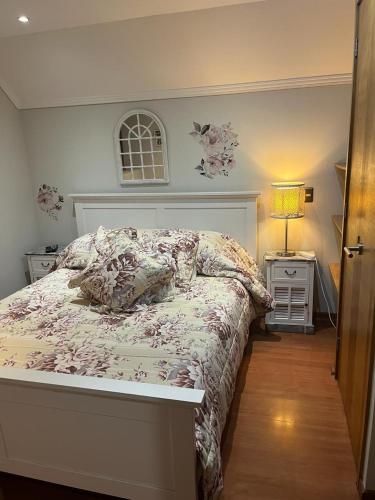 1 dormitorio con 1 cama y mesita de noche con lámpara en Habitación Matrimonial con baño privado en Santiago