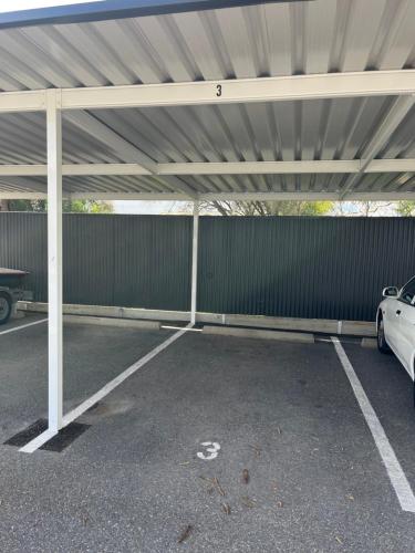 a garage with awning and a car parked under it at Moana Seaside Retreat - 2 Bedroom, spa , living area & pet friendly in Moana