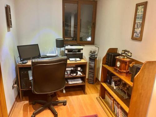 an office with a desk with a computer and a chair at Habitación Matrimonial con baño privado in Santiago