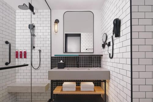 ein Badezimmer mit Waschbecken und Spiegel in der Unterkunft Moxy Putrajaya in Putrajaya