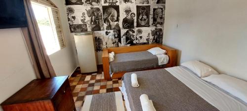 a small bedroom with two beds and a window at Suítes da Praça Tiradentes in Tiradentes