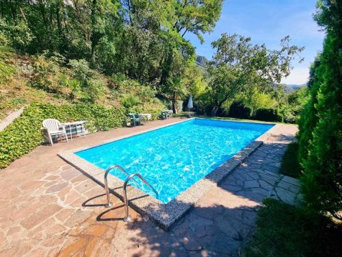 una piscina con una silla junto a ella en Suite Castel MeranO - panorama terrace and pool en Merano