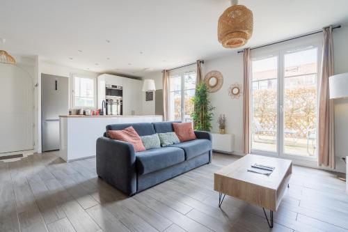 un salon avec un canapé bleu et une table dans l'établissement Disneyland House - Terrace - Sunny - Parking, à Serris