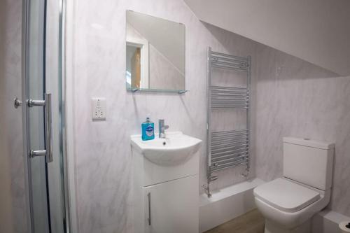 a white bathroom with a sink and a toilet at Stylish Central One Bed Studio in Manchester