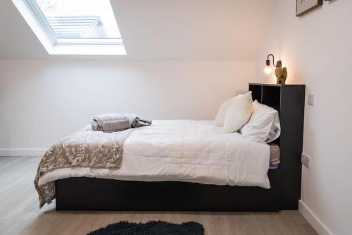 a bedroom with a bed with white sheets and a window at Stylish Central One Bed Studio in Manchester