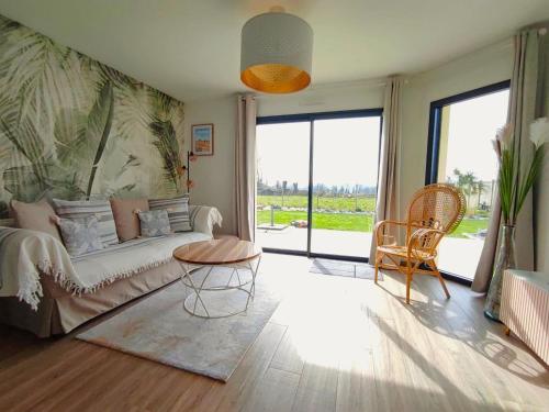 un soggiorno con divano e tavolo di Charming cottage only 8 minutes from Etretat a Bordeaux-Saint-Clair
