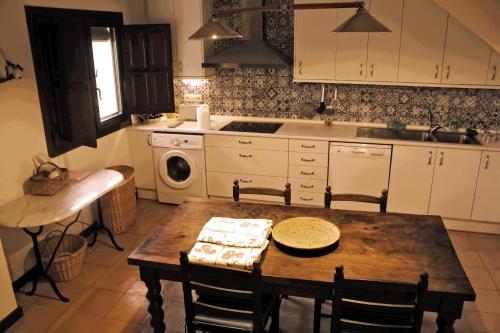 a kitchen with a wooden table with chairs and a sink at Casa el Tilo in Rubiales
