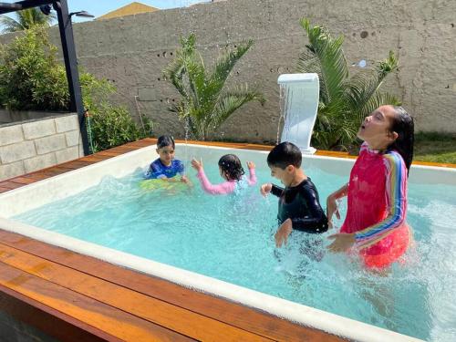 una mujer y tres niños en una piscina en La Famille - Casa de Praia I Arraial do Cabo, en Arraial do Cabo