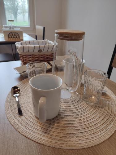 a table with cups and glasses on a table at La Rose Paisible in Brusson