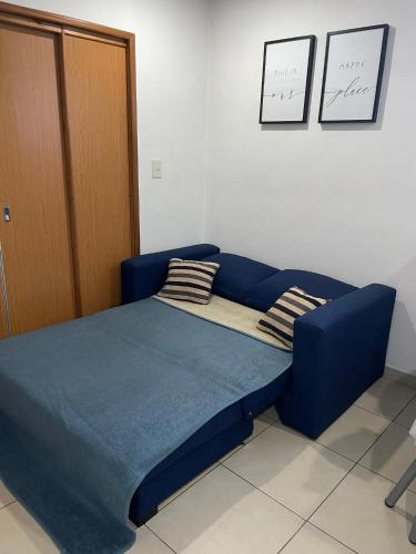 a blue bed in a room with two pillows on it at Studio Estrada Escobar in Belén de Escobar