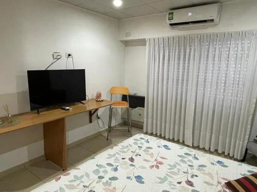 a room with a desk with a flat screen tv at Studio Estrada Escobar in Belén de Escobar