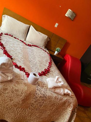 Una cama con una manta roja y blanca. en Rosita´s House Huaraz, en Huaraz
