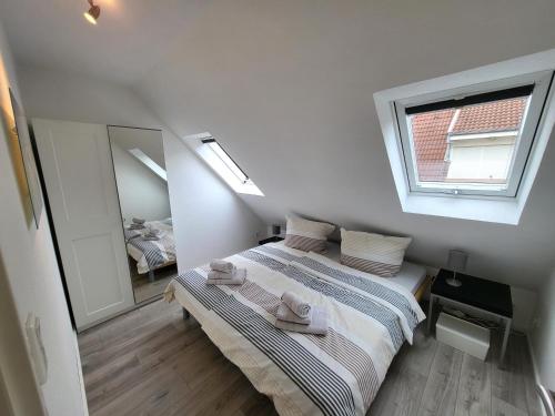 ein kleines Schlafzimmer mit einem Bett und einem Spiegel in der Unterkunft Ferienwohnung Ankerlicht in Norddeich