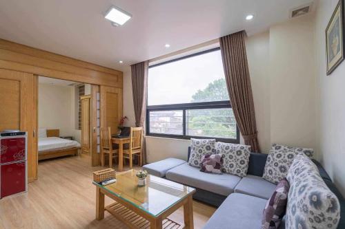 a living room with a couch and a large window at Cindy Hotel & Apartments - Khách Sạn Căn Hộ ở Trung Tâm TP Hải Phòng in Hai Phong