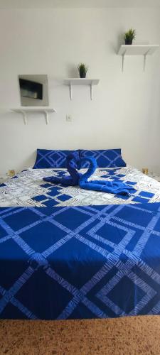 un edredón azul en una cama en un dormitorio en Sunny Room in Habitat, en Maspalomas
