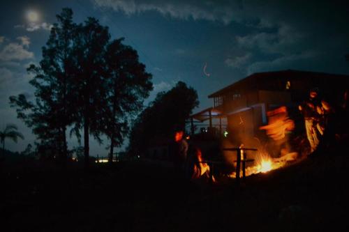 a group of people standing around a fire at night at CASA KAYAM Art Hostel Coliving Coworking in Guatapé
