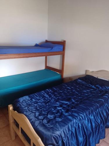 1 dormitorio con 2 literas con sábanas azules en La Soñada en Tandil
