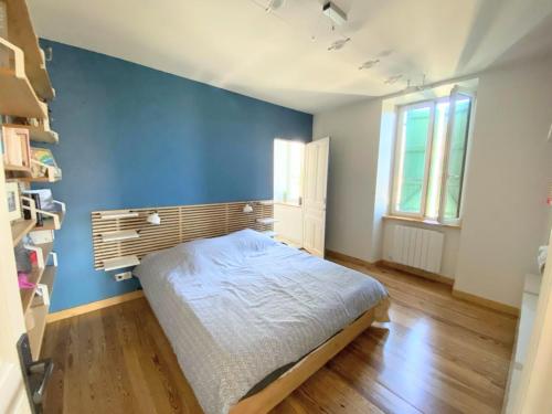 1 dormitorio con 1 cama con pared azul en Grand appart 115m² avec jardin+parking proche gare en Bellegarde-sur-Valserine