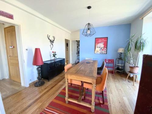 une salle à manger avec une table et des chaises en bois dans l'établissement Superbe appartement avec jardin et parking, à Bellegarde-sur-Valserine