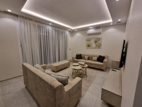 ein Wohnzimmer mit 2 Sofas und einem Tisch in der Unterkunft فلل شدا ورقان بالهدا in Al Hada