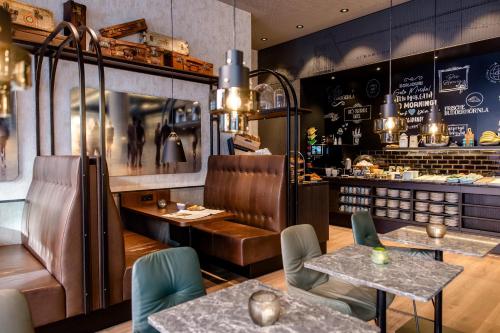a restaurant with two tables and chairs and a bar at Motel One Nürnberg-City in Nuremberg