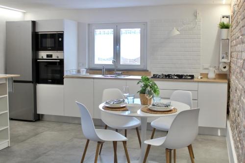 uma cozinha com uma mesa e cadeiras numa cozinha em BLUE HOUSE A casa di Tatta - apartments by the sea em Francavilla al Mare