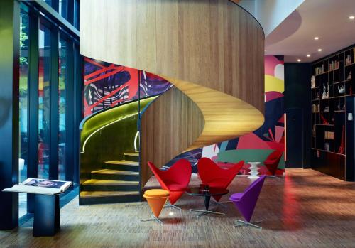 um átrio com cadeiras coloridas e uma escadaria em citizenM London Bankside em Londres