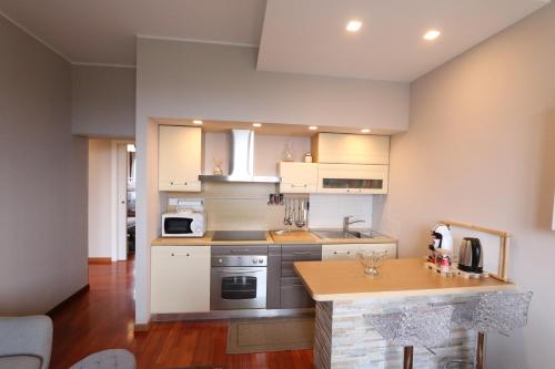 een keuken met witte kasten en een aanrechtblad bij casa Monia in Roe