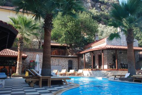 a resort with palm trees and a swimming pool at Dores Residence in Turunc