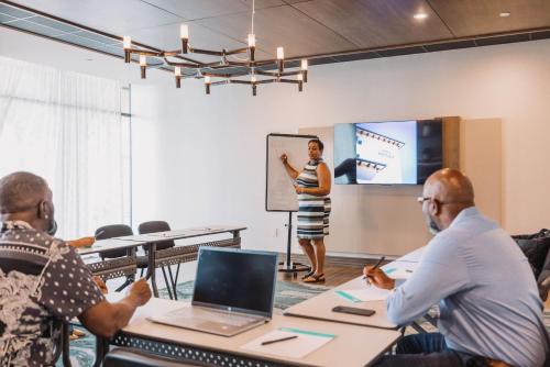 a group of people in a room with a woman giving a presentation at Hotel Indigo Spring - Woodlands Area by IHG in Spring
