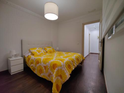 sypialnia z łóżkiem z żółto-białą kołdrą w obiekcie Casona Torrent w mieście Torrent