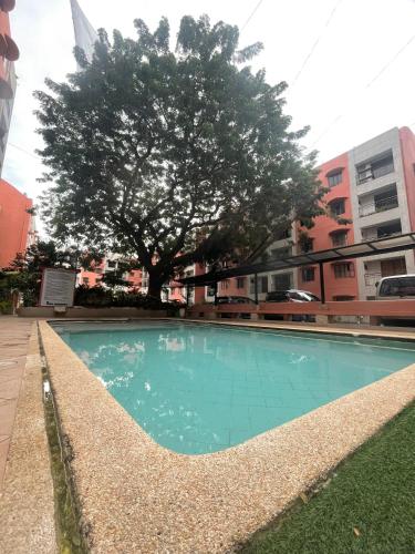 una piscina vacía con un árbol y edificios en The Penthouse Suite en Pusok