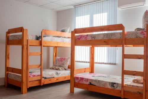 two bunk beds in a room with a window at Aydeniz hostel in Chişinău