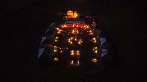 an overhead view of a table with lights at night at Aladdin merzouga camp in Merzouga