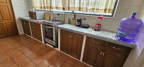 a kitchen with a bottle of water on the counter at Departamento Bien Ubicado con todo lo necesario in Latacunga