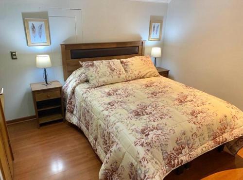 a bedroom with a bed and two night stands and two lamps at Habitación Matrimonial con Baño Privado 2 in Santiago