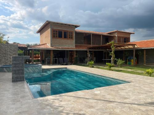 uma casa com piscina em frente a uma casa em Finca Hotel Casa Lupe En Santa Elena em El Cerrito