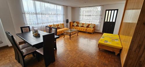 a living room with a couch and a table at Departamento Amplio con todo lo necesario in Latacunga